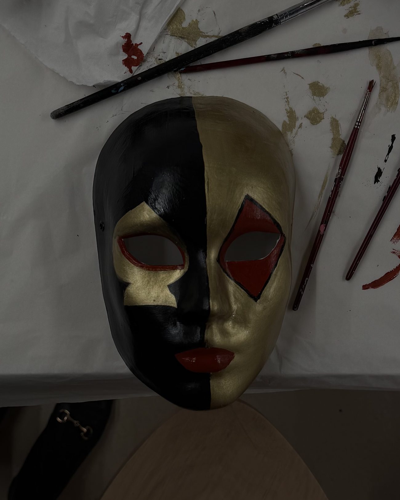 The mask, finished — black, gold, and a red mouth I didn't plan.